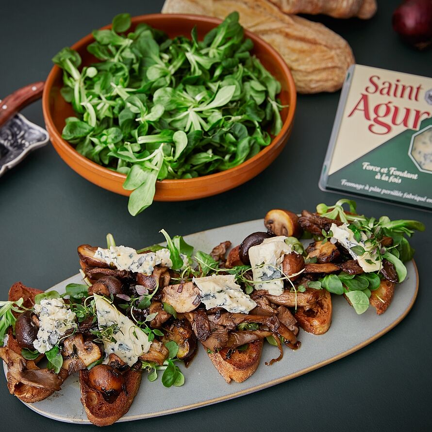 Geröstetes Bruschetta Brot belegt mit gebratenen Pilzen, Saint Agur Blauschimmelkäse und Salat